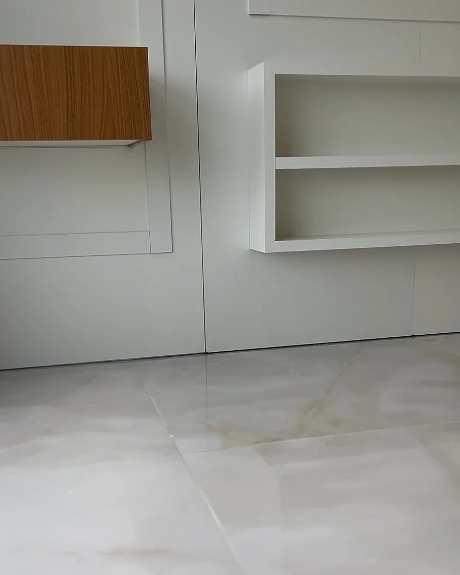 Estante embutida em marcenaria branca sobre piso em mármore, entregue em reforma da Si.Go